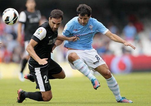Celta's midfielder Alejandro Lopez (R) fights for the ball with Malaga's defender Jesus Gamez